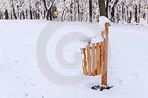 Wooden trash can covered with snow in forest winter season