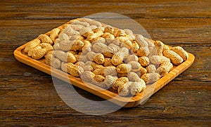 Wooden tray brimming with delicious peanuts.