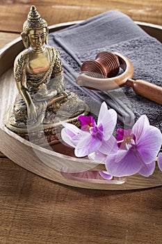 Wooden tray with Buddha and orchid flowers for spirituality and massage