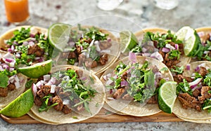 Wooden tray with carne asada tacos on corn tortilla