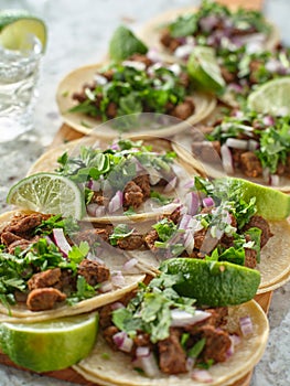 Wooden tray with carne asada tacos on corn tortilla