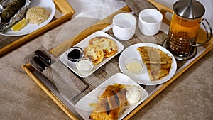 Wooden tray with food pancakes, cheesecakes, pastry with tea and ice-cream.