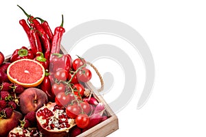 Wooden tray with fresh red vegetables and fruits on white background. Healthy eating vegetarian concept.