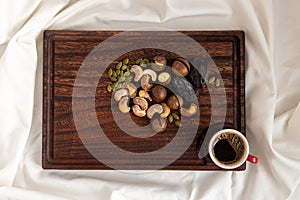 Wooden tray with various nuts on clean white bedding. Good morning concept.