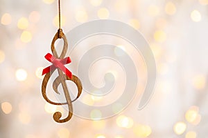 Wooden treble clef against blurred lights. Christmas music photo