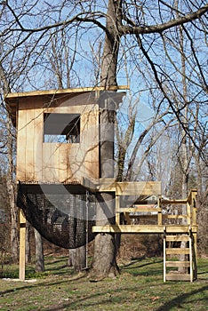 The wooden tree house is very close to the canal.