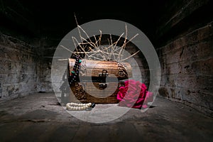 Wooden trunk with plants, a rose andtreasures in a stone background and mystery