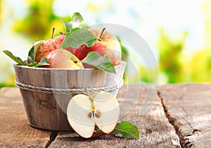 Wooden tub full and a halved fresh apple