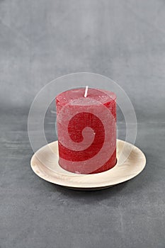 A wooden turned candle plate with a red candle