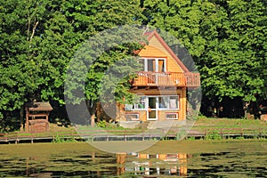 The wooden two-storeyed house with a well in the wood