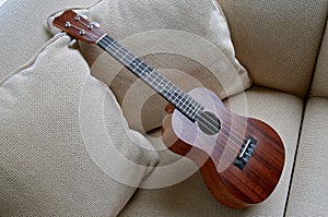 Wooden ukulele left on a couch