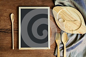 wooden utensil in kitchen on old wooden background with blackboard