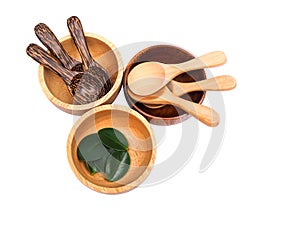Wooden utensil set with spoon and wooden bowl with green leaf isolated on white background