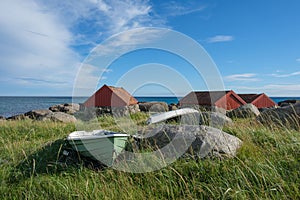 Wooden vessel on a grassy shoreline against rural houses on Brusand Beach, Norway