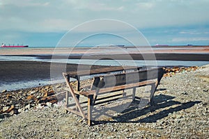 Wooden viewing bench on a receding beach photo