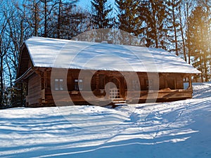 Wooden vintage country house in mountains forest covered snow on nature landscape. Active rest. Snowy winter holidays