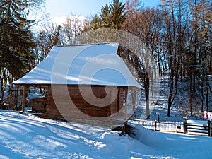 Wooden vintage country house in mountains forest covered snow on nature landscape. Active rest. Snowy winter holidays