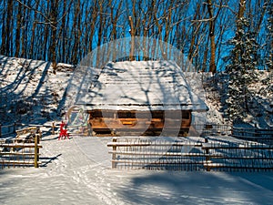 Wooden vintage country house in mountains forest covered snow on nature landscape. Active rest. Snowy winter holidays