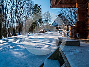 Wooden vintage country house in mountains forest covered snow on nature landscape. Active rest. Snowy winter holidays