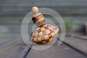 Wooden vintage spinning top over a table with blurry background photo
