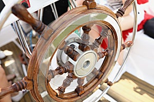 Wooden vintage steering wheel on a yacht close-up