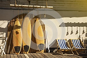 Wooden vintage Surfboard and Bamboo fence stands in the sand