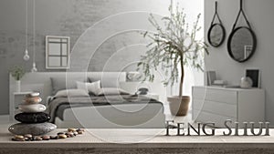 Wooden vintage table shelf with pebble balance and 3d letters making the word feng shui over blurred bedroom with window, chest of