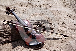 The wooden violin ahd bow put beside timber board,on the beach photo