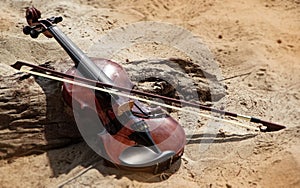 The wooden violin ahd bow put beside timber board,on the beach photo