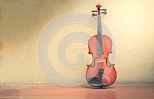 Wooden violin with old wall and wood floor