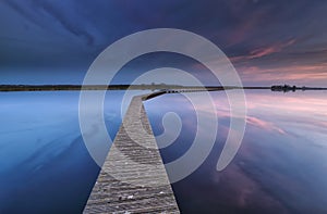 Wooden walkpath on water at dawn