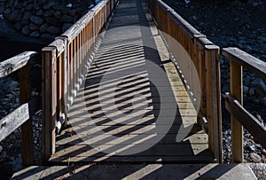 Wooden walking bridge crossing river canyon