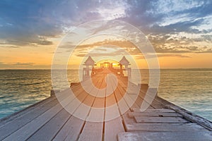 Wooden walking path leading to sunset seacoast skyline