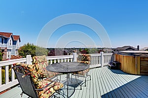 Wooden walkout deck with outdoor settees and hot tub