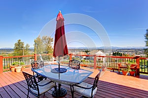 Wooden walkout deck with patio table overlooking beautiful landscape