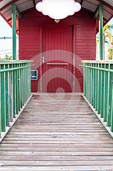 Wooden walkway with access to mini red house