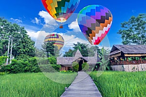 Wooden walkway and balloons with green rice fields in Vang Vieng, Laos