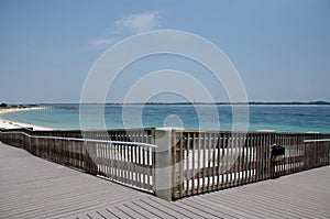 Wooden walkway leading to the beach and pier with view of the sea. Beautiful view of Florida bay. White sand beaches.