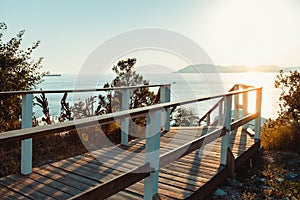 Wooden walkway leading to seashore against backdrop of sunset Sunny Summer Beach Relaxing Concept Gelendzhik