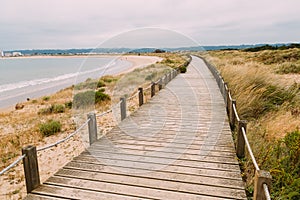 De madera acera empieza a lo largo de bahía a Playa de hacer 