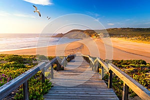 Wooden walkway to the beach Praia da Amoreira, District Aljezur, Algarve Portugal. Panorama from Amoreira beach in the Algarve