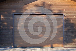 Wooden wall and automatic garage door in brown color