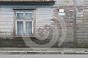 Wooden wall of the old house with a window and a sign as background