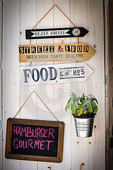 Wooden wall with placards and a blackboard hanging. Restaurants.