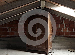 Wooden wardrobe in the dusty uninhabited attic photo