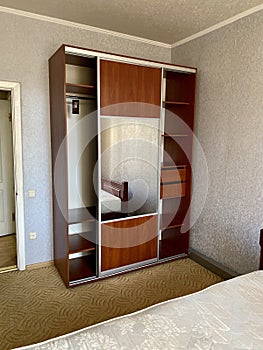 Wooden wardrobe with a mirror in the bedroom