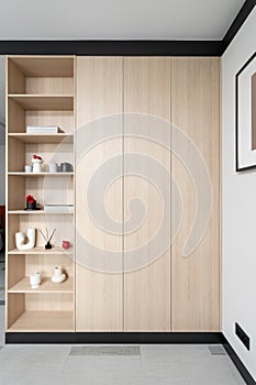 Wooden wardrobe with shelves for keeping different things at living room