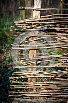 Wooden wattle fense in autumn garden