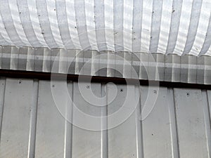 Wooden weatherboard painted white with paper ridged louvre shutter photo