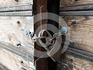 Wooden weathered antique gates closed with padlock